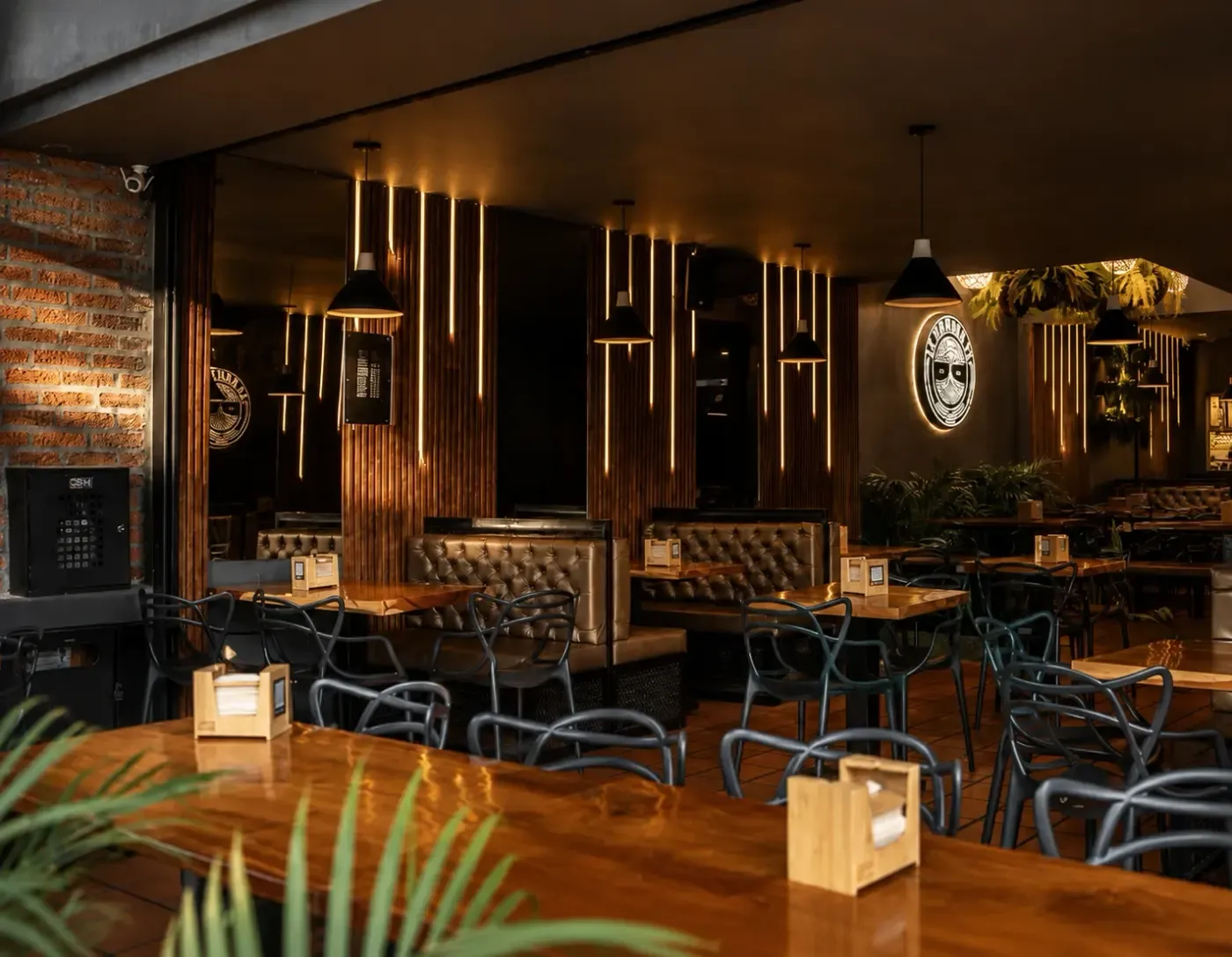 Salón de La Patrona St., restaurante diseñado por DAPI, con paneles de madera iluminados